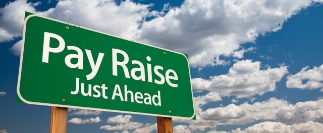 Pay Raise, Just Ahead Green Road Sign with Copy Room Over The Dramatic Clouds and Sky.